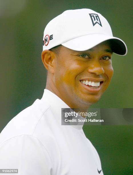 Tiger Woods laughs on the range during a practice round prior to the start of THE TOUR Championship at East Lake Golf Club on September 23, 2009 in...