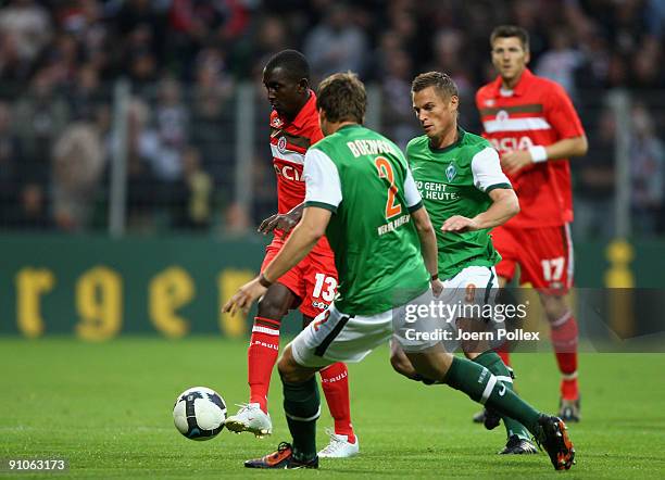 Markus Rosenberg and Sebastian Boenisch of Bremen as well as Charles Takyi of St. Pauli battle for the ball during the DFB Cup second round match...