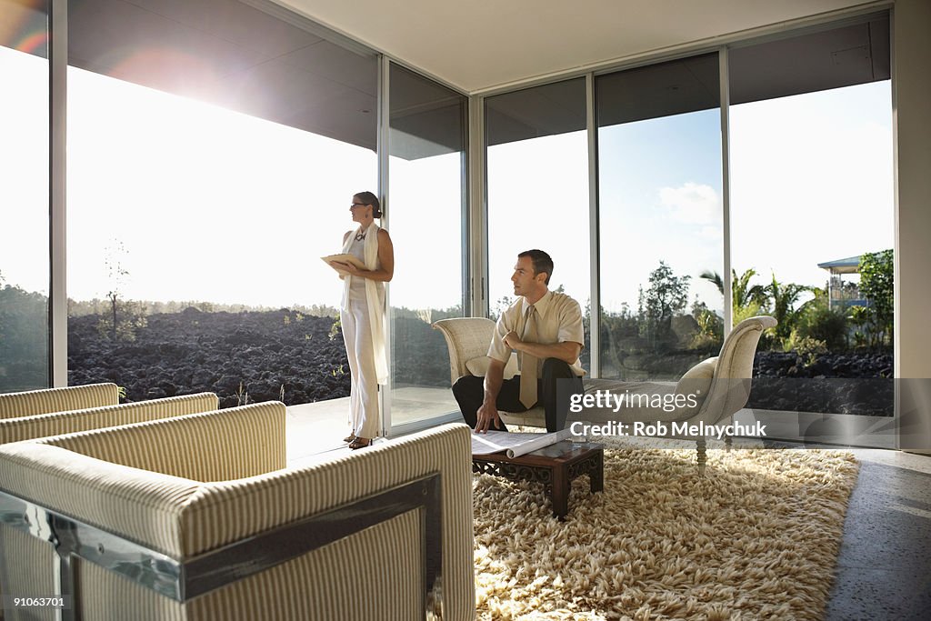 Man and Woman looking out window in modern room.