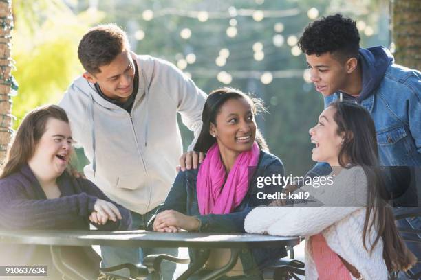 vijf jeugdvrienden praten, één met syndroom van down - alleen tieners stockfoto's en -beelden