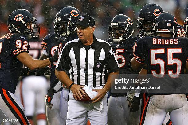 Referee tries to keep the football dry as the Chicago Bear defense including Hunter Hillenmeyer, Anthony Adams and Lance Briggs await the start of...