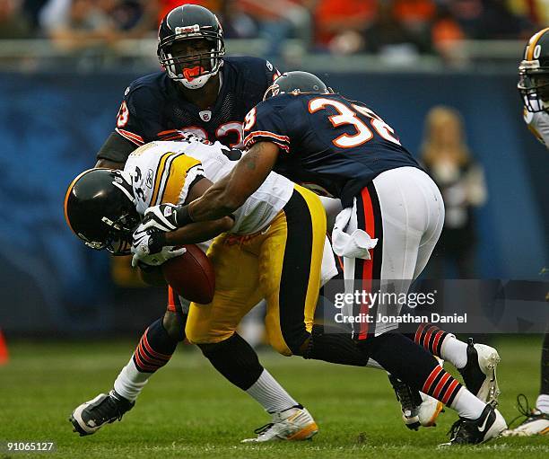 Willie Parker of the Pittsburgh Steelers drops the ball as he is hit by Danieal Manning and Charles Tillman of the Chicago Bears on September 20,...