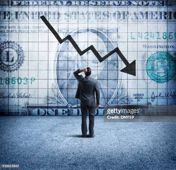 empresario mirando para arriba en una tabla que indica una caída del dólar estadounidense - rezession fotografías e imágenes de stock