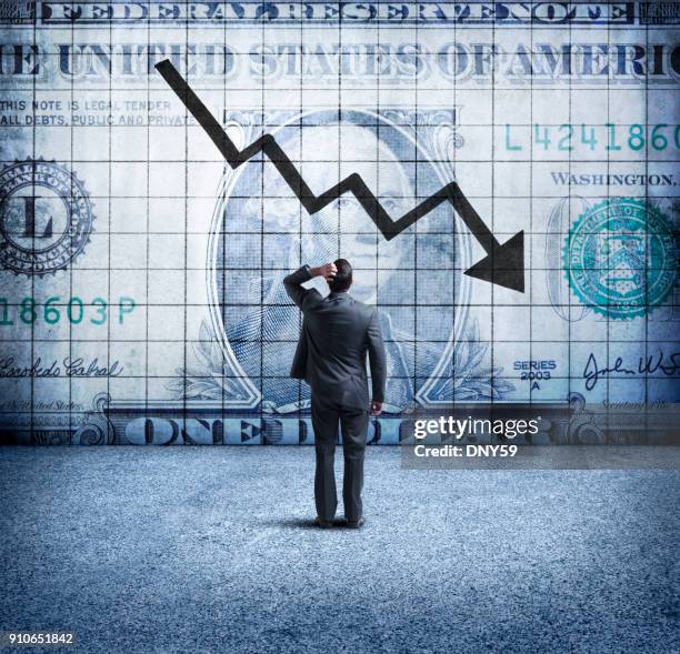 zakenman op zoek op een grafiek die een dalende amerikaanse dollar aangeeft - indecisive stockfoto's en -beelden