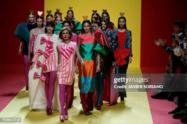 Spanish designer Agatha Ruiz de la Prada walks on the catwalk with models after presenting her Fall/Winter 2018/19 collection during the Madrid...