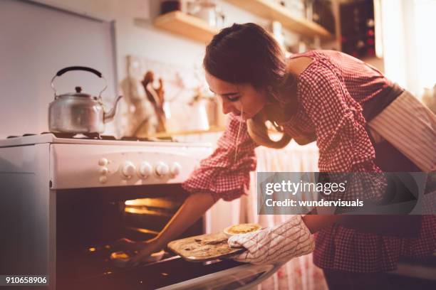 junge frau in küche ofen zum backen von torten platzieren - old fashioned thanksgiving stock-fotos und bilder