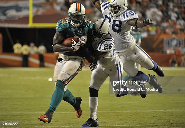 Running Back Ronnie Brown of the Miami Dolphins carries the ball as Kelvin Hayden and Robert Mathis of the Indianapolis Colts try to tackle him...