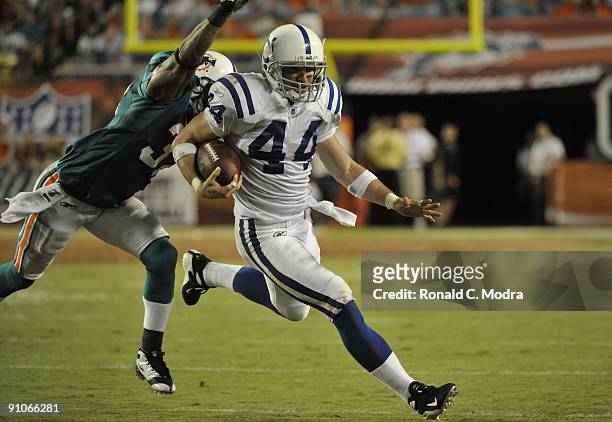 Tight end Dallas Clark of the Indianapolis Colts carries the ball as Yeremiah Bell of the Miami Dolphins tries to stop him at Land Shark Stadium on...