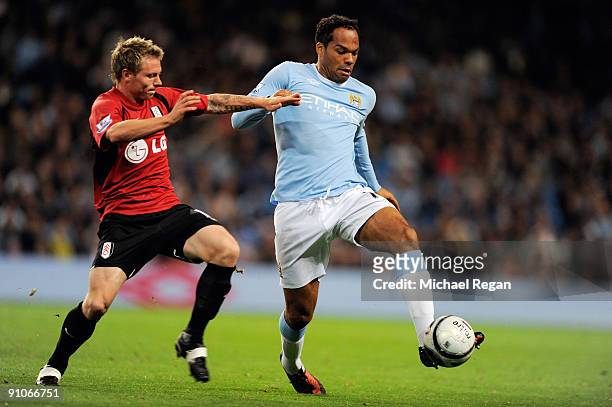 Joleon Lescott of Manchester City battles with Bjorn Riise of Fulham during the Carling Cup third round match between Manchester City and Fulham at...