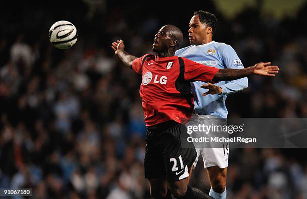 Joleon Lescott of Manchester City battles with Eddie Johnson of Fulham during the Carling Cup third round match between Manchester City and Fulham at...