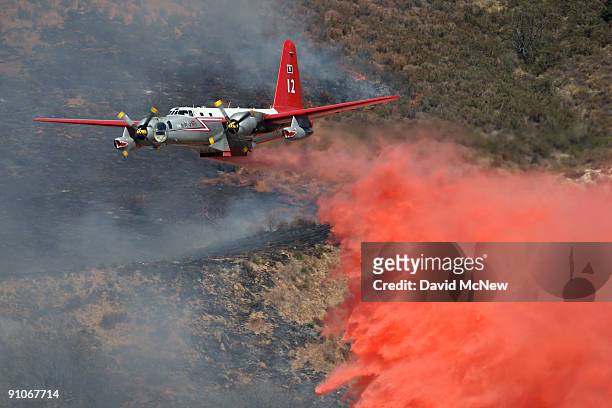 Firefighting aircraft drops fire retardant to try to control the southeastern flank of the nearly 10,000-acre Guiberson fire, burning out of control...