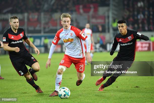 Joshua Mees of Regensburg runs with the ball as Tobias Levels and Alfredo Morales of Ingolstadt are behind him during the Second Bundesliga match...
