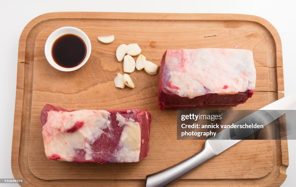 Pot roast preparing step with beef chuck, garlic and soy sauce.