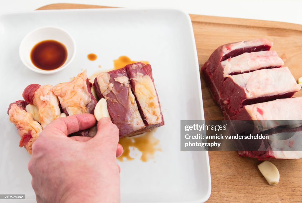 Chuck beef with slivers of garlic having been rolled in soy sauce.