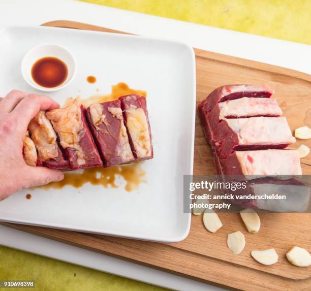 chuck beef with slivers of garlic having been rolled in soy sauce. - schmorbraten stock-fotos und bilder