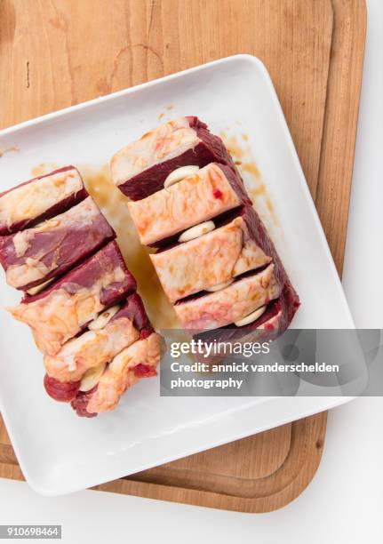 chuck beef with slivers of garlic having been rolled in soy sauce. - schmorbraten stock-fotos und bilder