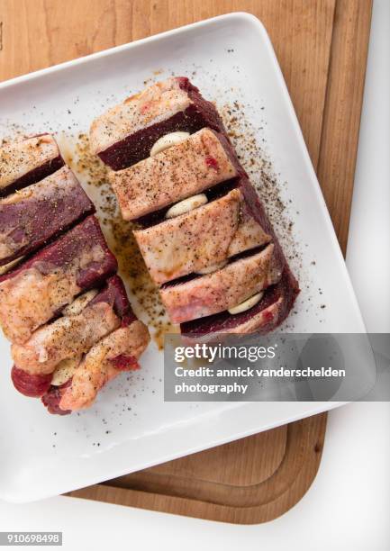 chuck beef with slivers of garlic having been rolled in soy sauce. - schmorbraten stock-fotos und bilder