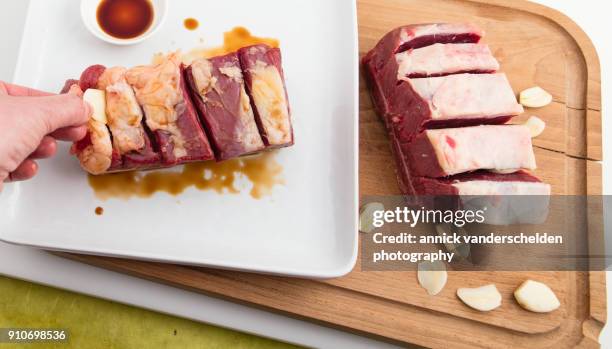 chuck beef with slivers of garlic having been rolled in soy sauce. - schmorbraten stock-fotos und bilder