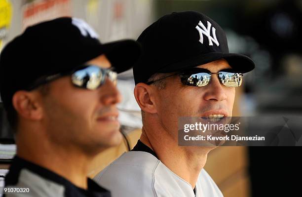 Manager Joe Girardi of the New York Yankees sits next to pitcher Andy Pettitte in the dugout before the start of the baseball game against Los...