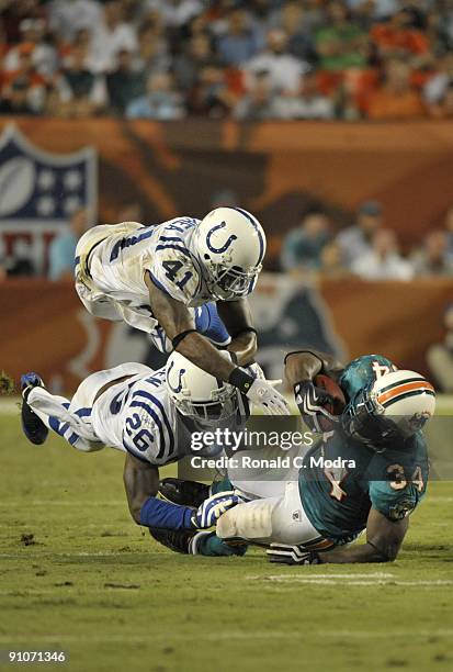 Ricky Williams of the Miami Dolphins is stopped by Antoine Bethea and Kelvin Hayden of the Indianapolis Colts during a NFL game at Land Shark Stadium...