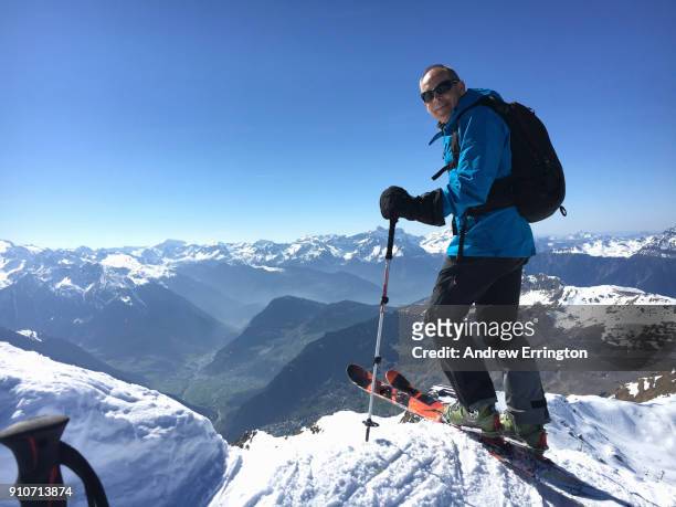 man 55-60years old, on telemark skis, smiling, looking to camera with view of swiss alps behind - 55 59 years 個照片及圖片檔