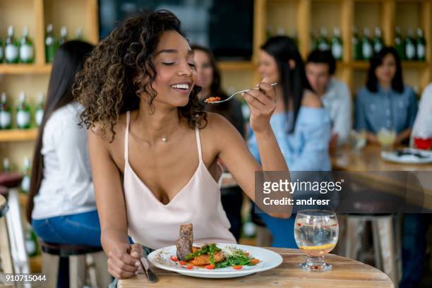 beautiful woman eating at a restaurant - african dining stock pictures, royalty-free photos & images