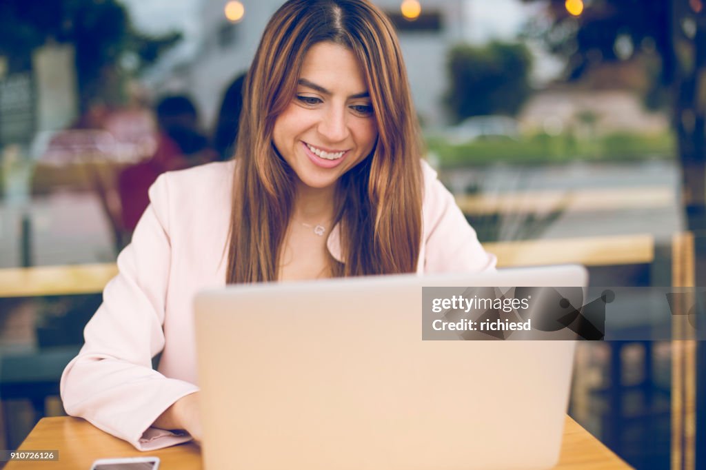 Happy businesswoman working in a coffee store