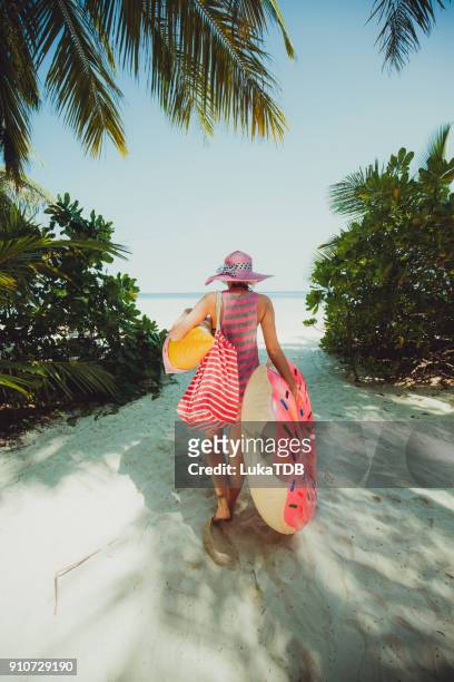 mujer hipster caminando por la selva en la carretera a la costa, maldivas - aura fotografías e imágenes de stock