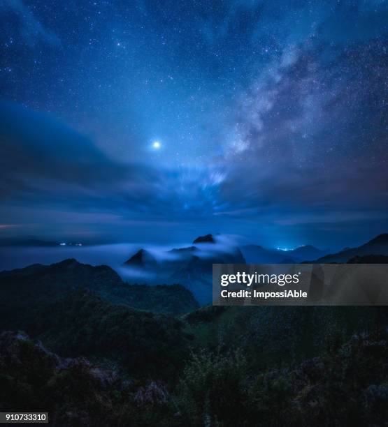 milky way above the mountainous landscape with misty at night - scène tranquille brume photos et images de collection