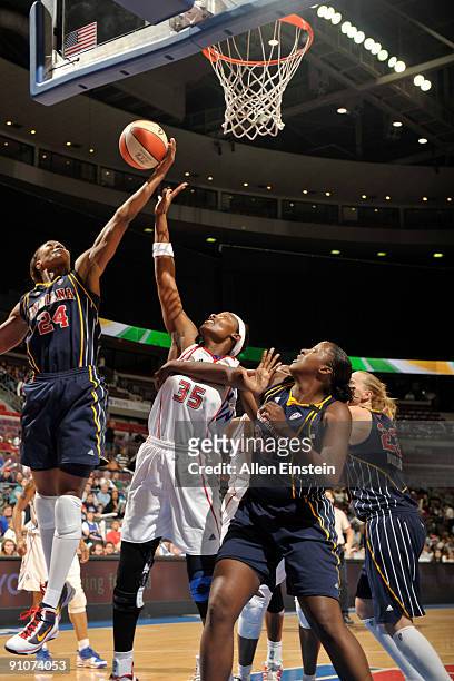 Tamika Catchings of the Indiana Fever grabs a rebound over Cheryl Ford of the Detroit Shock in Game One of the WNBA Eastern Conference Finals on...