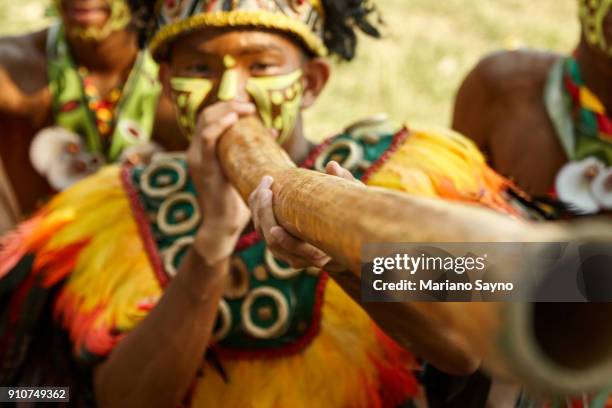 a tribesman playing didgeridoo at festival - dinagyang festival - fotografias e filmes do acervo