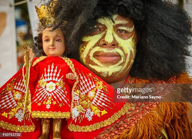 tribesman holding a saint at festival - dinagyang festival stock pictures, royalty-free photos & images