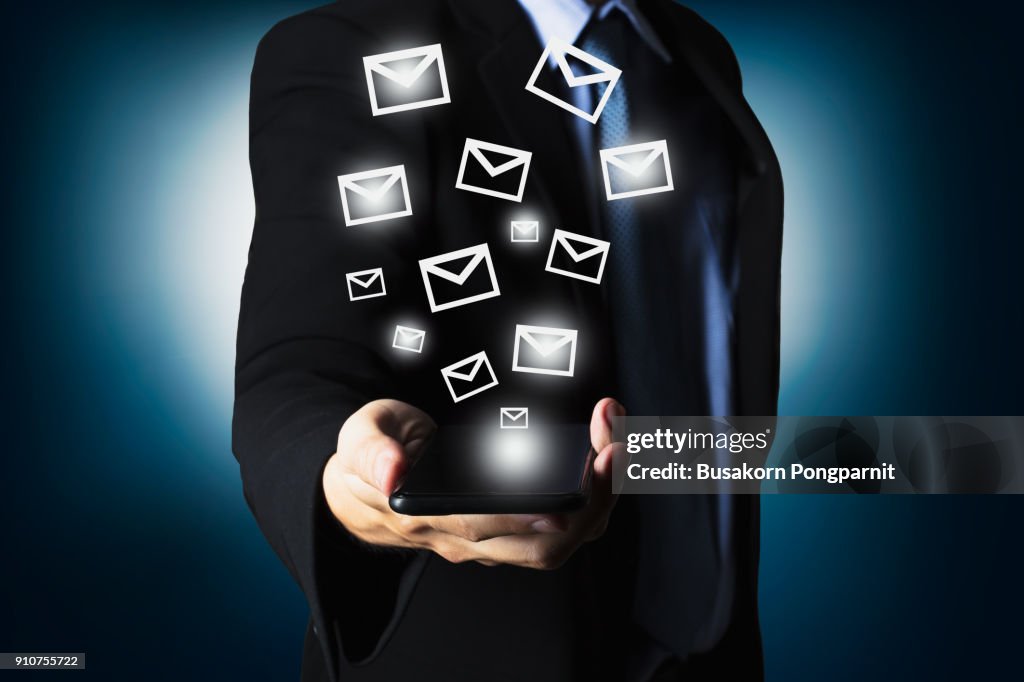 Businessman using smartphone sending massage with email icon