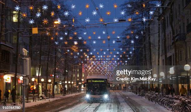beautiful holiday lights on a snowy street in zurich, cable car & bikes - mackay street stock pictures, royalty-free photos & images