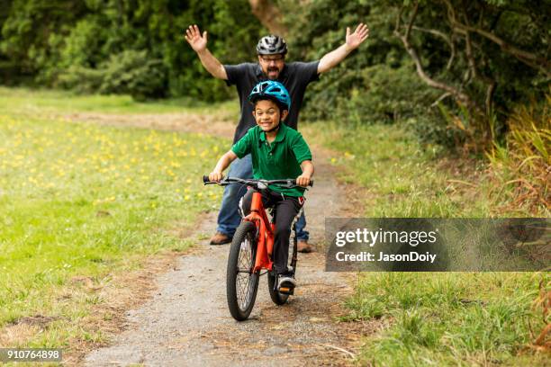 vader en zoon fiets rijden - first occurrence stockfoto's en -beelden