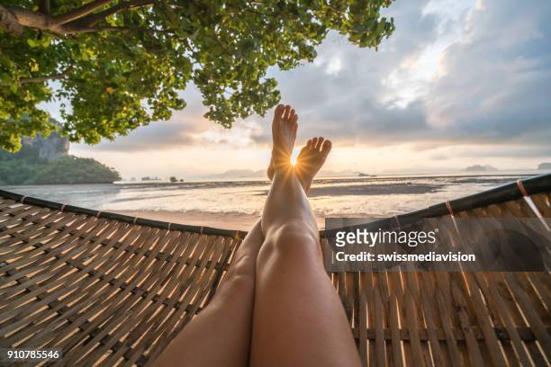 personal perspective of woman relaxing on hammock, feet view - his foot imagens e fotografias de stock