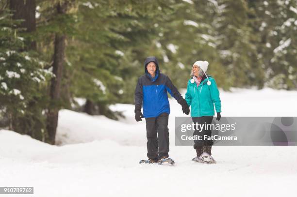 senior snowshoeing adventure! - winter sport walk old stock pictures, royalty-free photos & images