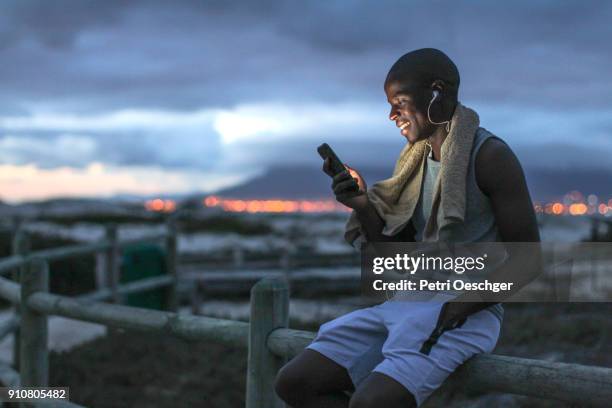 a young black man in exercise clothing outdoors before sunrise - sport equipment stock-fotos und bilder