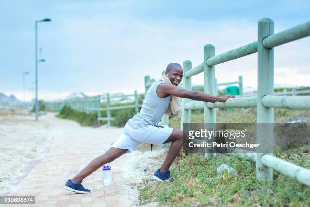 a young black man stretching. - black male bodybuilders 個照片及圖片檔