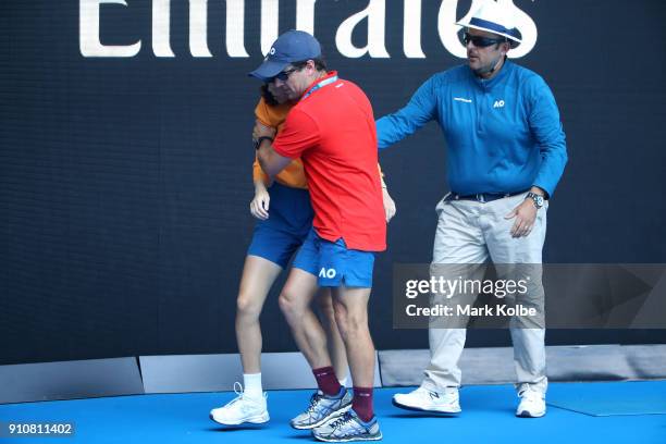 Ballkid is helped from the court after struggling in the heat during the Australian Open 2018 Junior Championships at Melbourne Park on January 27,...