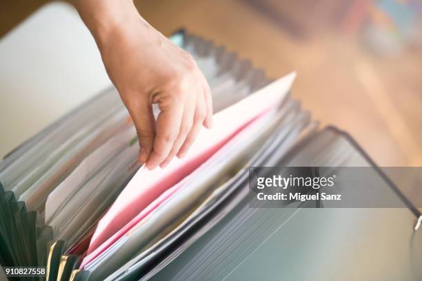 woman looking for in the folders and file - filing documents stock pictures, royalty-free photos & images