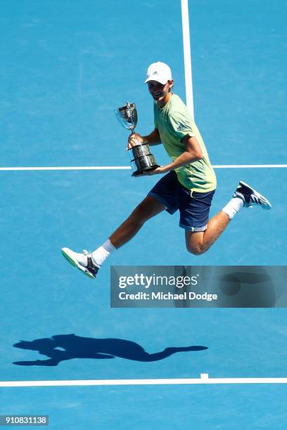 Sebastian Korda of the United States poses with the championship trophy after winning his Junior Boys' Singles Final against Chun Hsin Tseng of...