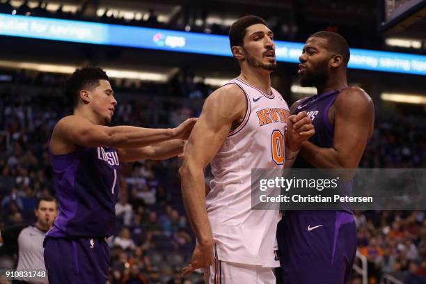 Devin Booker of the Phoenix Suns pushes Enes Kanter of the New York Knicks into Greg Monroe during the second half of the NBA game at Talking Stick...