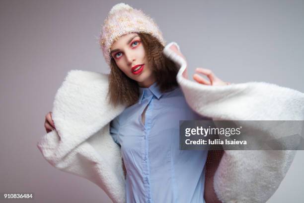 woman putting on coat - gray coat stock pictures, royalty-free photos & images