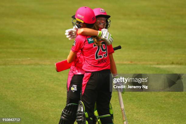 Alyssa Healy of the Sixers celebrates her century with Erin Burns during the Women's Big Bash League match between the Adelaide Strikers and the...