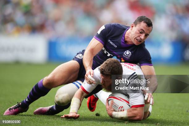 Stephen Tomasin of USA is tackled by Scott Riddell of Scotland during day two of the 2018 Sydney Sevens at Allianz Stadium on January 27, 2018 in...