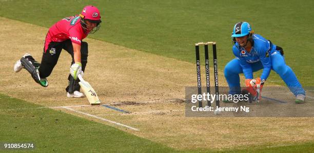 Alyssa Healy of the Sixers makes her ground as Tegan McPharlin of the Strikers gathers the ball during the Women's Big Bash League match between the...