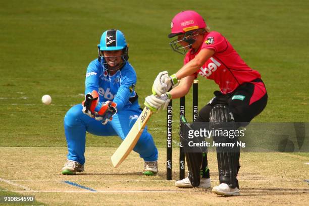 Alyssa Healy of the Sixers plays a shot as Tegan McPharlin of the Strikers wicketkeeps during the Women's Big Bash League match between the Adelaide...