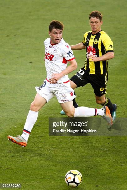 Ryan Strain of Adelaide United holds off the challenge of Michael McGlinchey of the Phoenix during the round 18 A-League match between the Wellington...