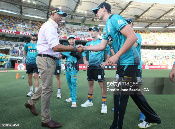 Former QLD player Andrew Symonds presents Matthew Renshaw with a Heat cap during the Big Bash League match between the Brisbane Heat and the...